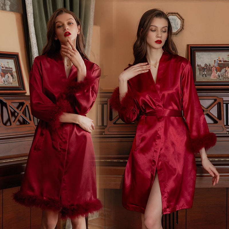 Elegant red satin robe with fur trim, featuring a belted waist and stylish design, perfect for luxurious loungewear.