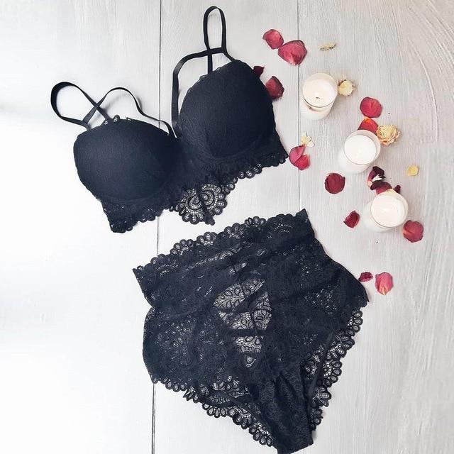 Black lace lingerie set featuring a padded bralette with delicate straps and high-waisted sheer lace panties, surrounded by rose petals and candles.