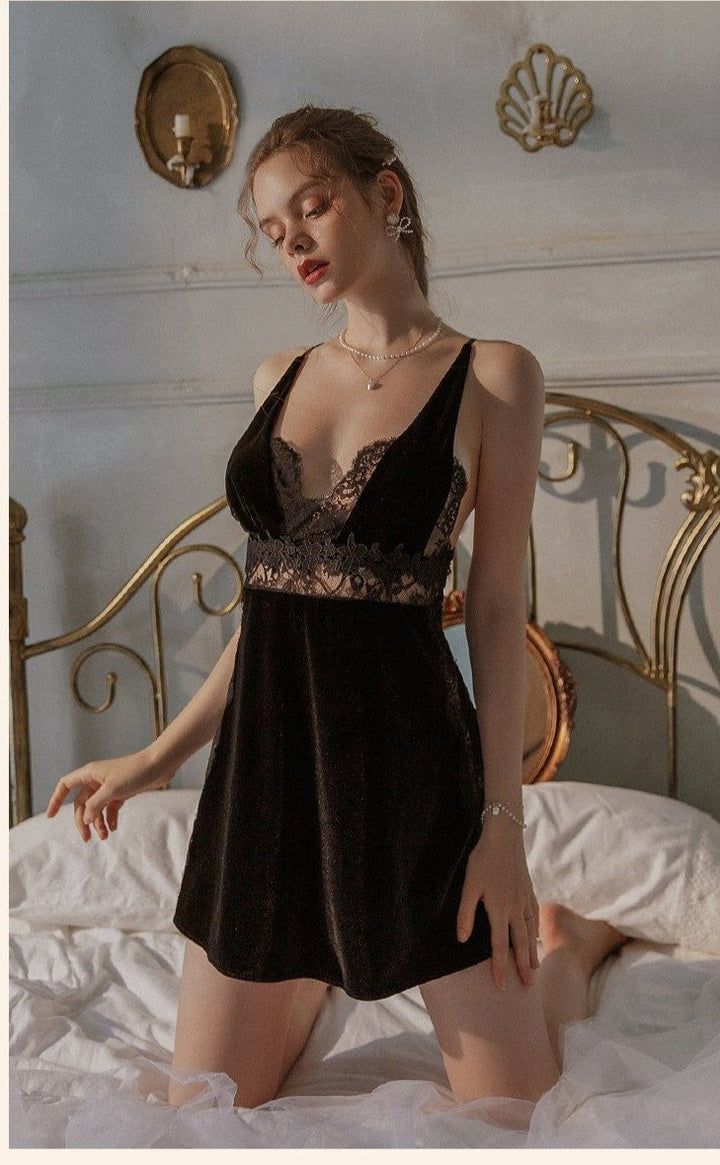 Black velvet lingerie nightdress with lace detailing, styled on a model in a cozy bedroom setting.