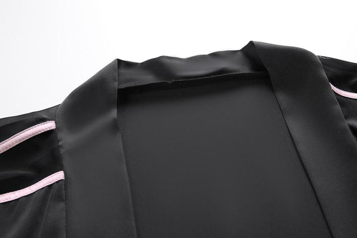 Black satin robe with pink trim, featuring a smooth neckline and elegant design, perfect for luxurious lounging or intimate occasions.