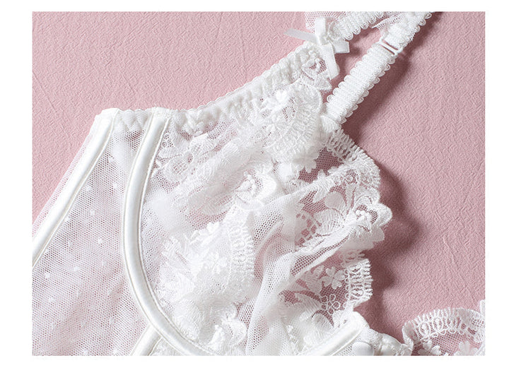 White lace lingerie featuring delicate floral patterns and adjustable straps, set against a soft pink background.