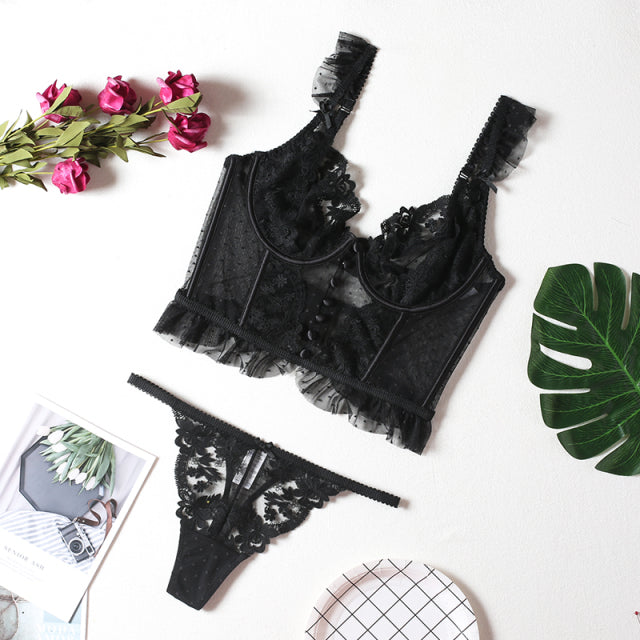Black lace lingerie set featuring a ruffled bralette and matching thong, styled with floral details.