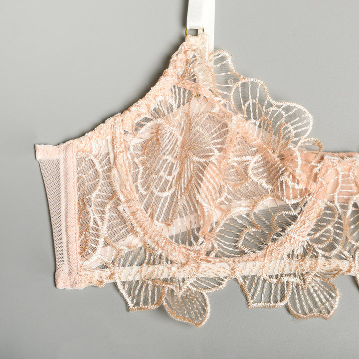 Elegant blush lace bralette featuring intricate floral embroidery and soft mesh detailing, perfect for a subtle and stylish lingerie look.