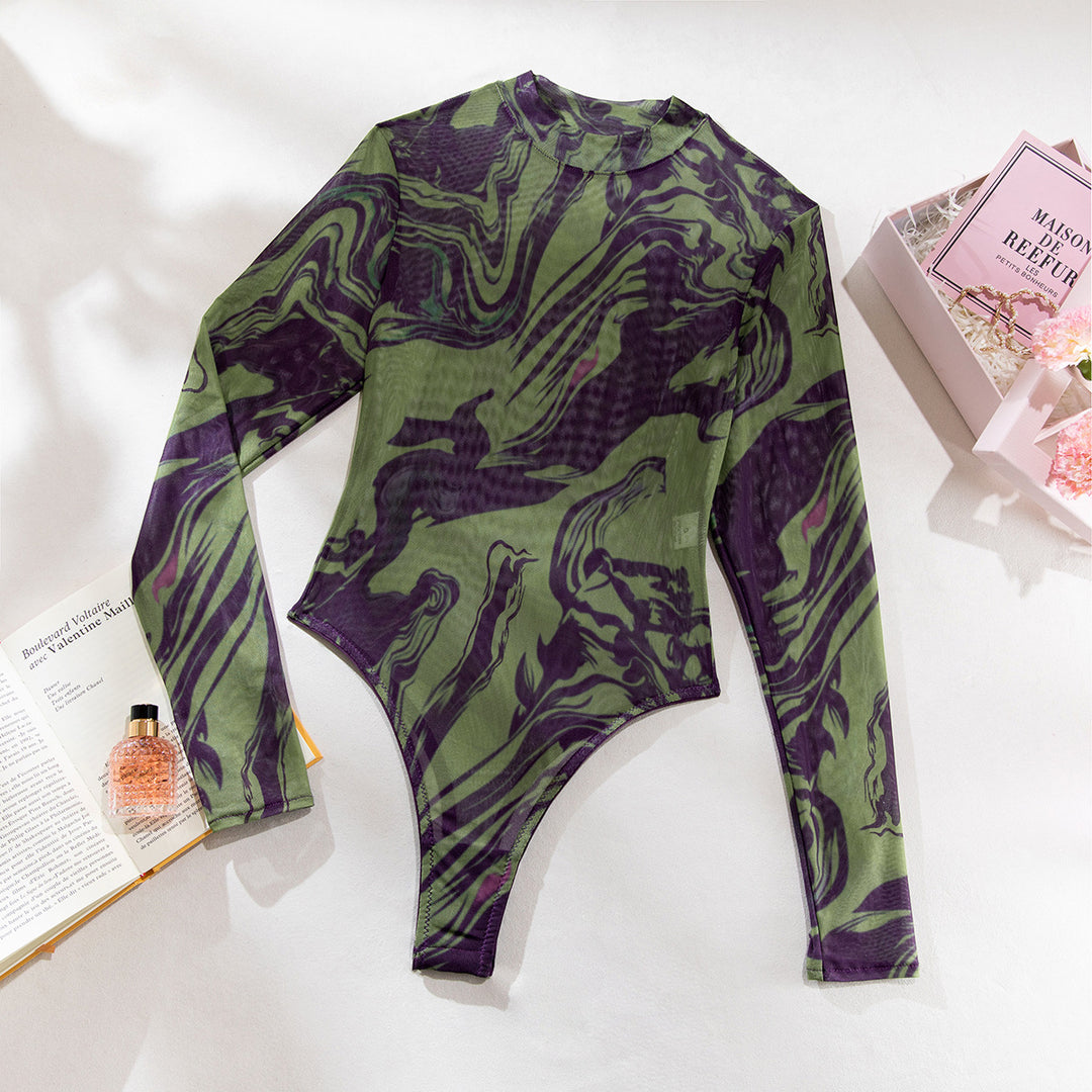 Long-sleeve mesh bodysuit in green and purple marble print displayed on a clean background with a fragrance bottle and book.