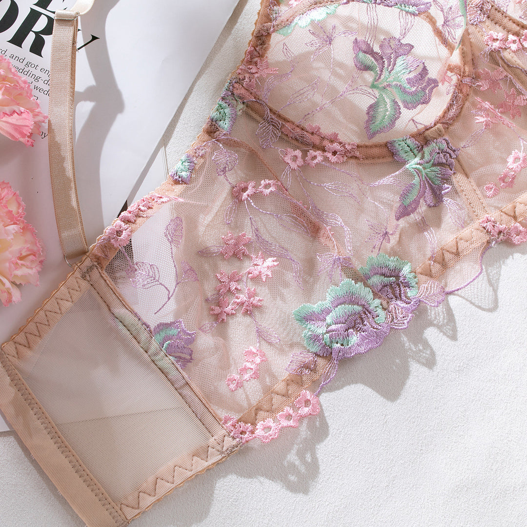 Delicate floral lace bralette featuring intricate embroidery in pastel colors, set against a nude background, perfect for adding a touch of elegance to your lingerie collection