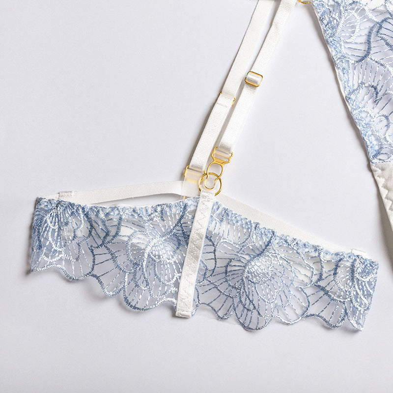 Light blue lace bralette with floral design and adjustable white straps featuring gold accents.