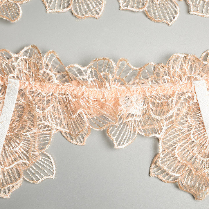 Delicate floral lace fabric in soft peach tones, featuring intricate detailing and a smooth elastic band for comfort, perfect for elegant lingerie sets.