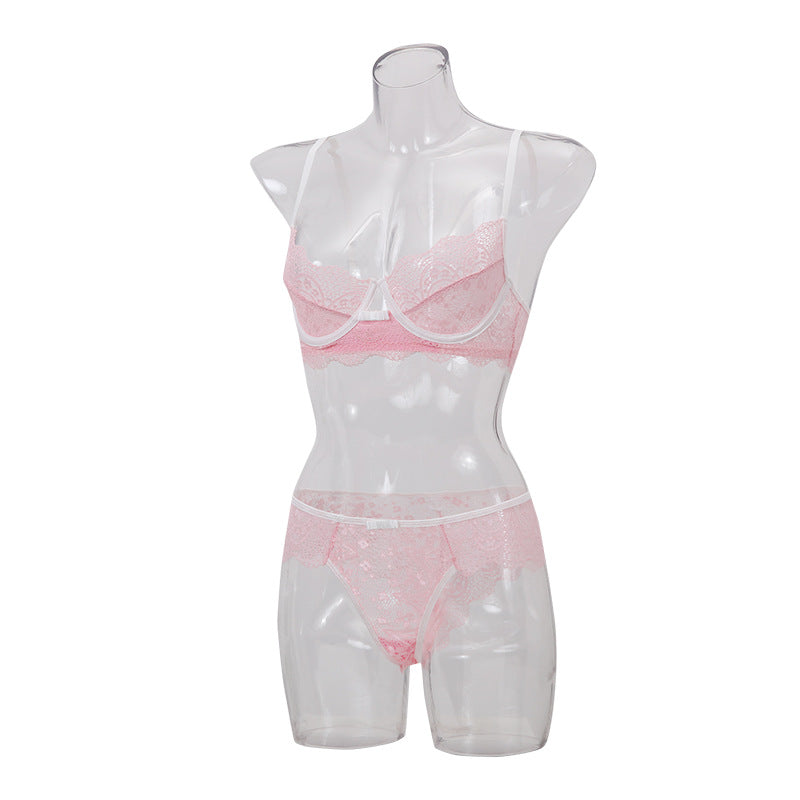 Pink lace lingerie set displayed on a clear mannequin, featuring a bralette and matching bottoms with delicate detailing.