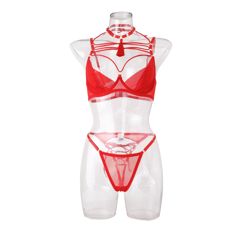 Red lingerie set featuring a bra and thong with intricate strapping details, designed for sensual appeal and comfort. The bra includes a choker-style neckline with