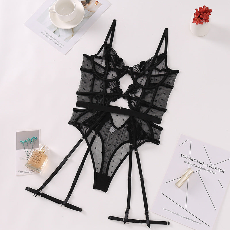 Black lace and mesh bodysuit with polka dot detailing and adjustable straps, featuring garter attachments for added allure.