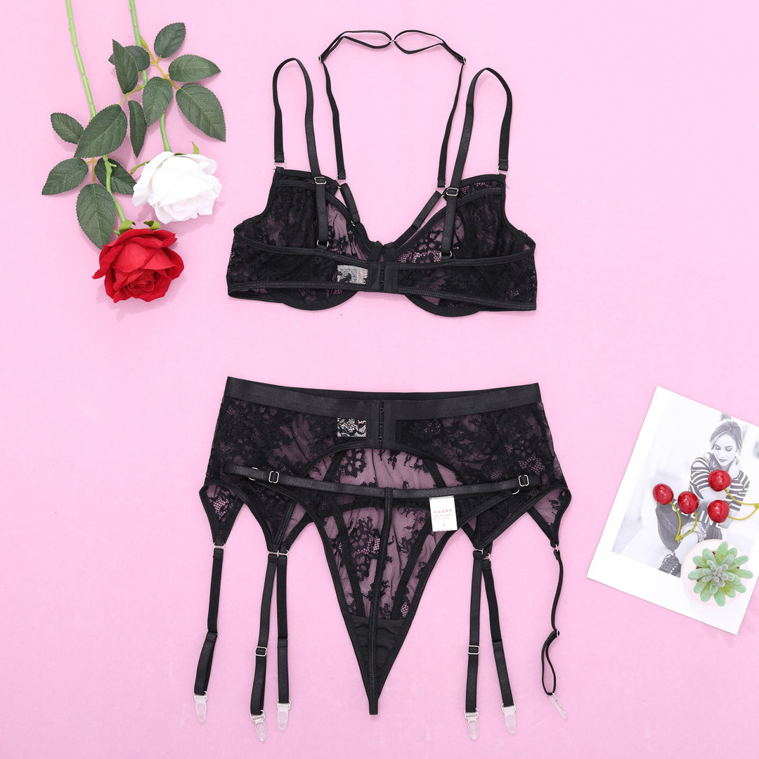 Black lace lingerie set featuring a bralette and garter belt, styled with delicate floral patterns and adjustable straps, against a pink background.