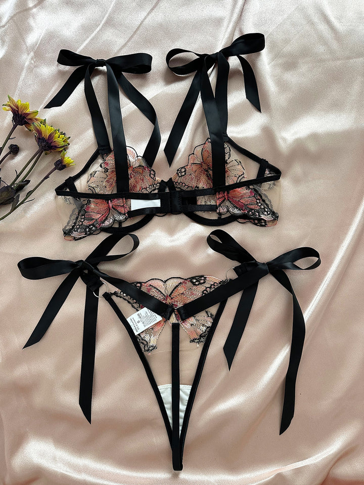 Elegant floral lace lingerie set featuring a bralette with delicate black ribbons and butterfly embroidery, complemented by a matching thong adorned with intricate designs. Perfect for romantic