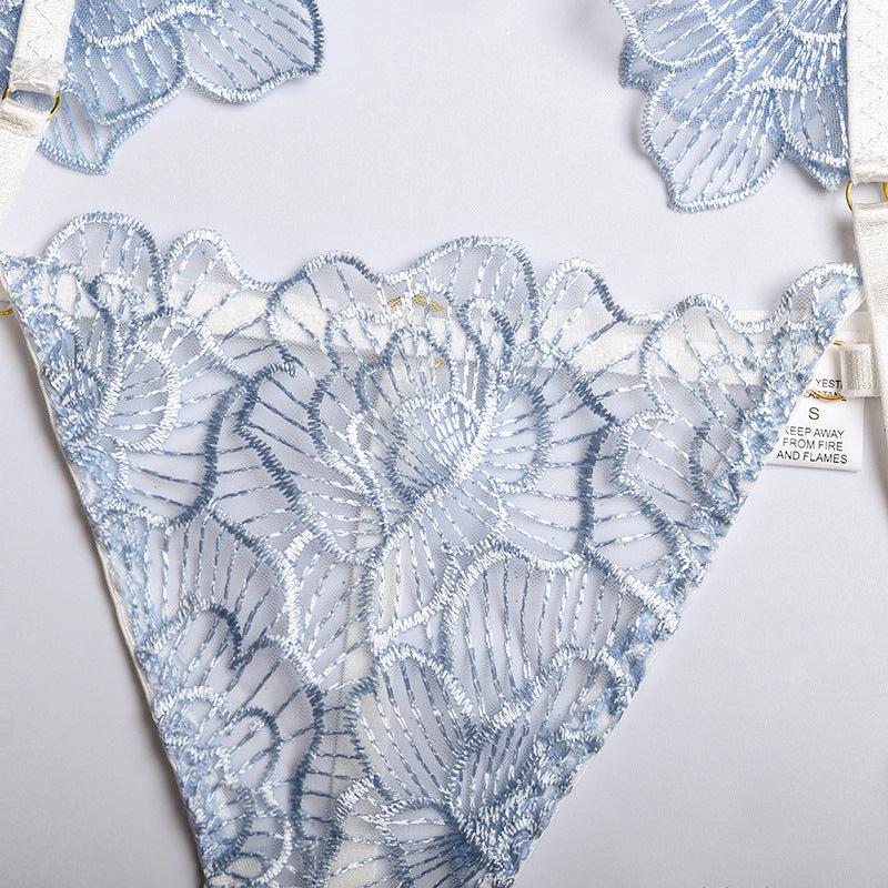 Light blue embroidered lace lingerie with floral design and adjustable straps, showcasing delicate craftsmanship and elegance.