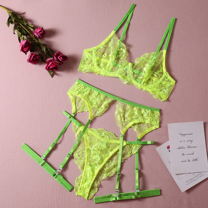 Neon yellow lace lingerie set featuring a bralette with thin straps and matching panties with strappy details, styled on a soft pink background with roses and a note.