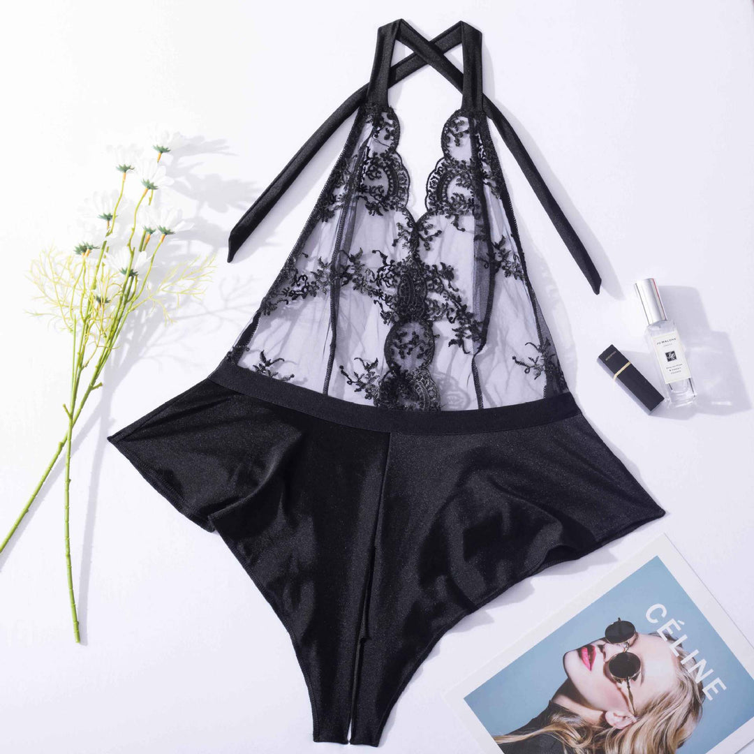 Black lace and satin lingerie set with halter neck design, featuring intricate detailing and a flattering silhouette, styled with beauty products and floral accents.