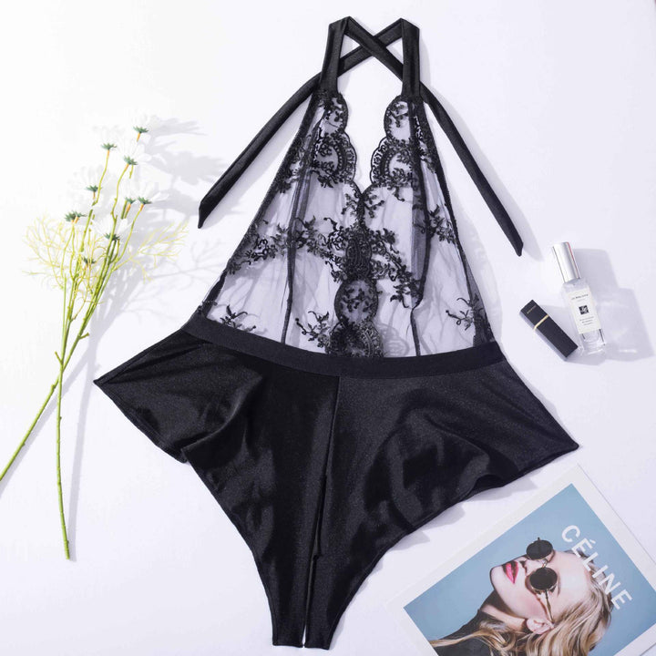 Black lace and satin lingerie set with halter neck design, featuring intricate detailing and a flattering silhouette, styled with beauty products and floral accents.