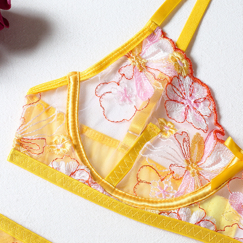 Floral embroidered bralette in yellow featuring sheer mesh fabric, delicate pink and orange flower designs, and adjustable straps; perfect for a romantic and stylish lingerie