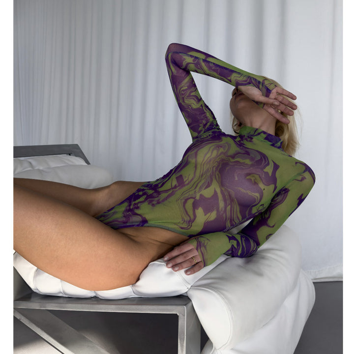 Long-sleeve sheer bodysuit in a vibrant purple and green marbled pattern, featuring a high neckline and form-fitting design, showcased on a