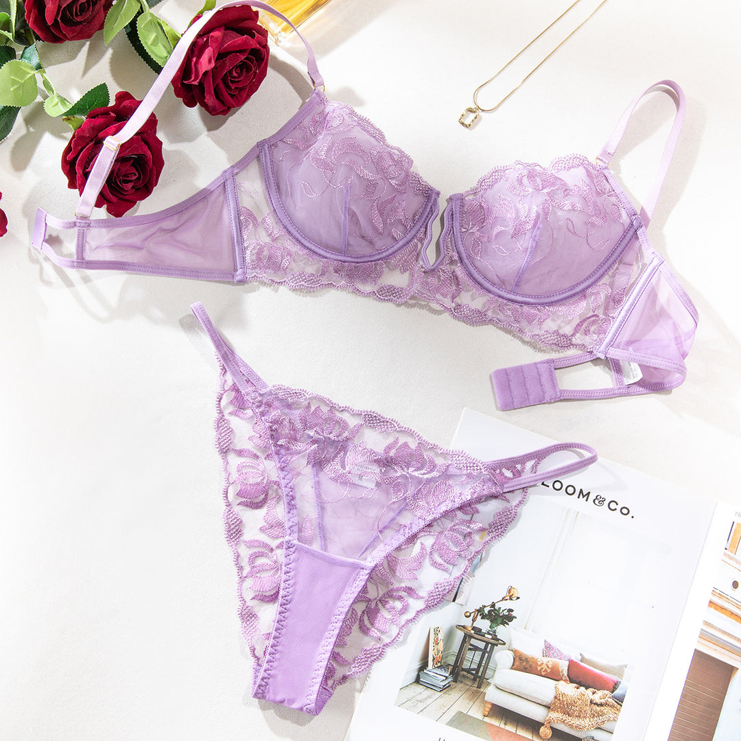 Purple lace bra and thong set with floral details, styled with roses and a magazine on a light background.