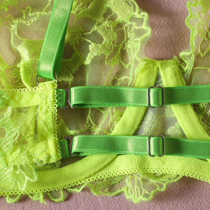 Neon green lace bra with adjustable straps and intricate floral detailing.