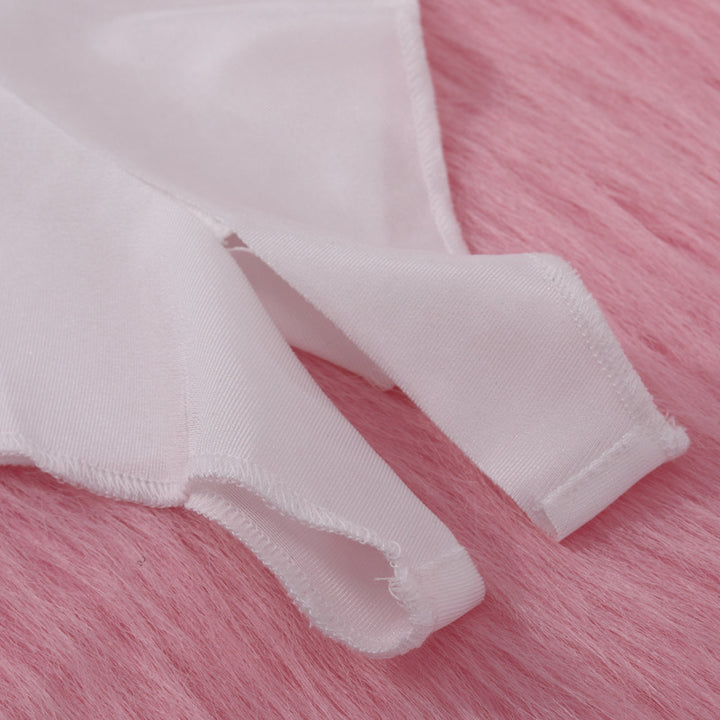 Close-up of soft white lingerie straps on a pink fur background.