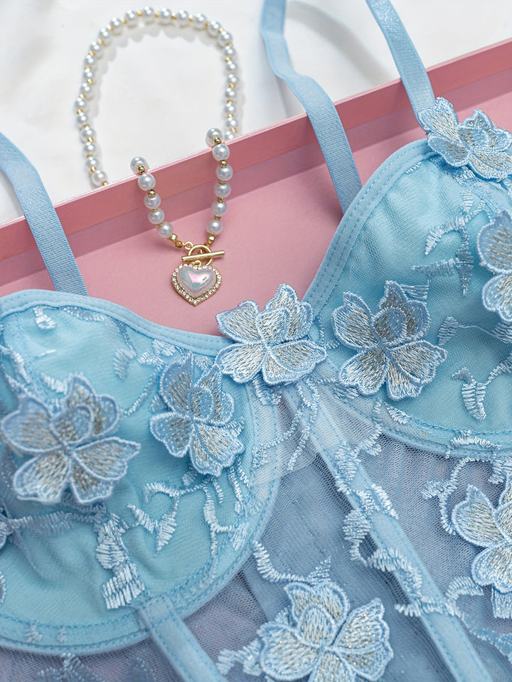 Lingerie set featuring delicate blue floral embroidery, adjustable straps, and a sheer overlay, accompanied by a pearl necklace with a heart-shaped pendant, all