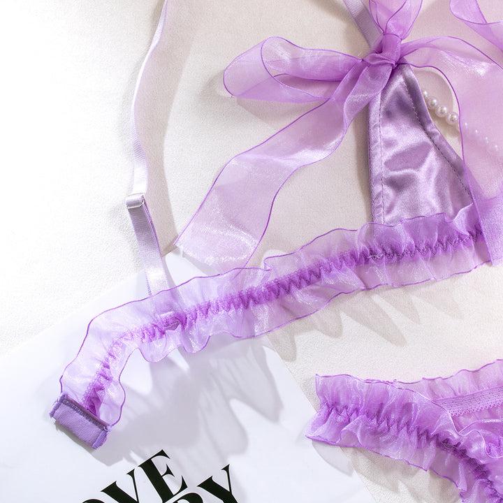 Lavender satin lingerie set featuring delicate sheer ruffles and adjustable ties, perfect for a romantic evening.