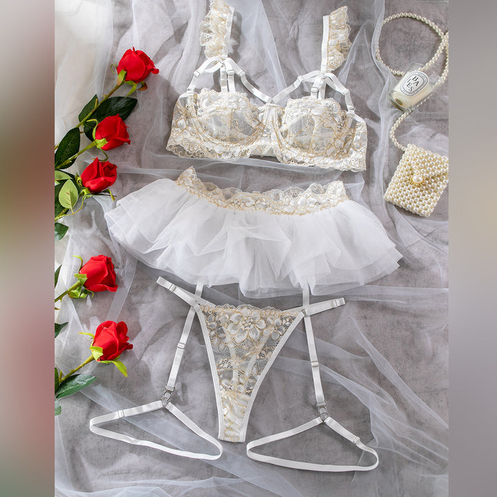 Elegant lace lingerie set featuring a beautifully detailed balconette bra, a flirty tulle garter skirt, and a matching thong, all adorned with intricate