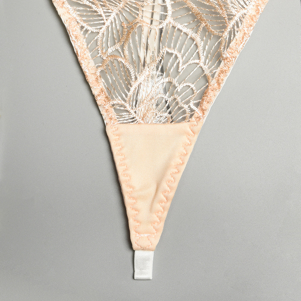 Delicate lace thong with floral embroidery and soft peach fabric detailing, ideal for elegant lingerie collections.