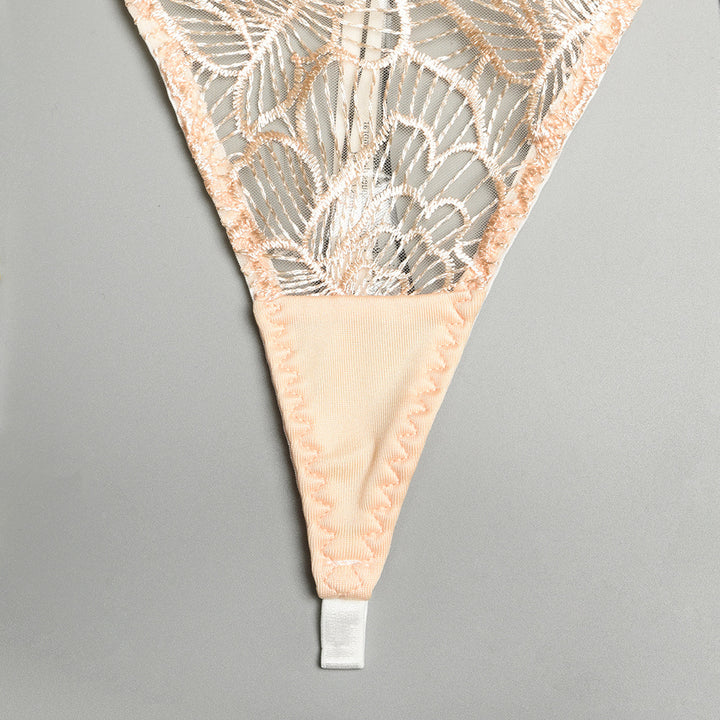 Delicate lace thong with floral embroidery and soft peach fabric detailing, ideal for elegant lingerie collections.