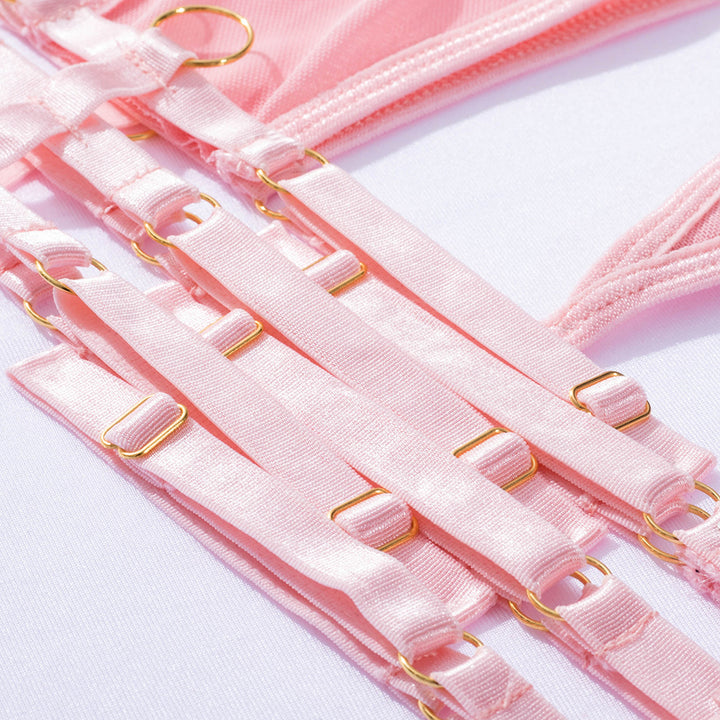 Close-up of delicate pink lingerie straps featuring gold metal accents, showcasing a blend of elegance and comfort. The soft fabric and adjustable design ensure a perfect fit