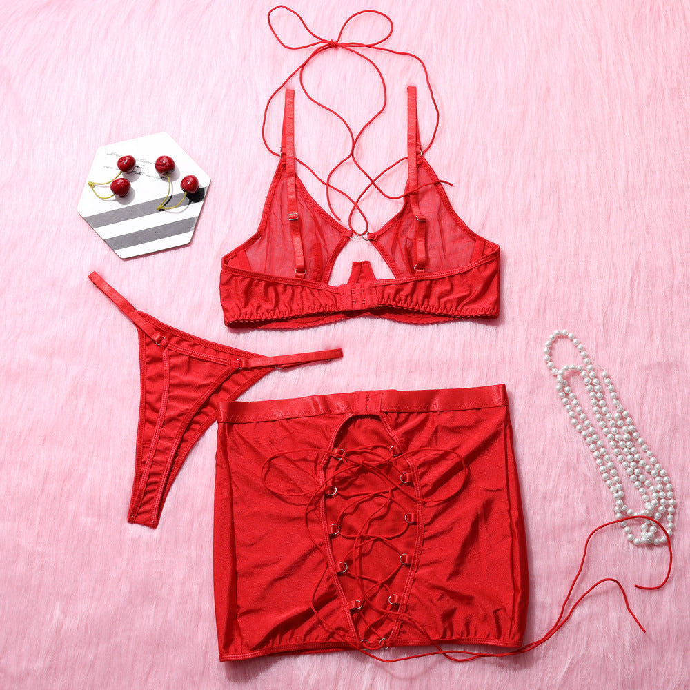 Red sheer lingerie set featuring a strappy bralette, matching thong, and a lace-up skirt. The delicate design showcases soft fabric with adjustable straps,