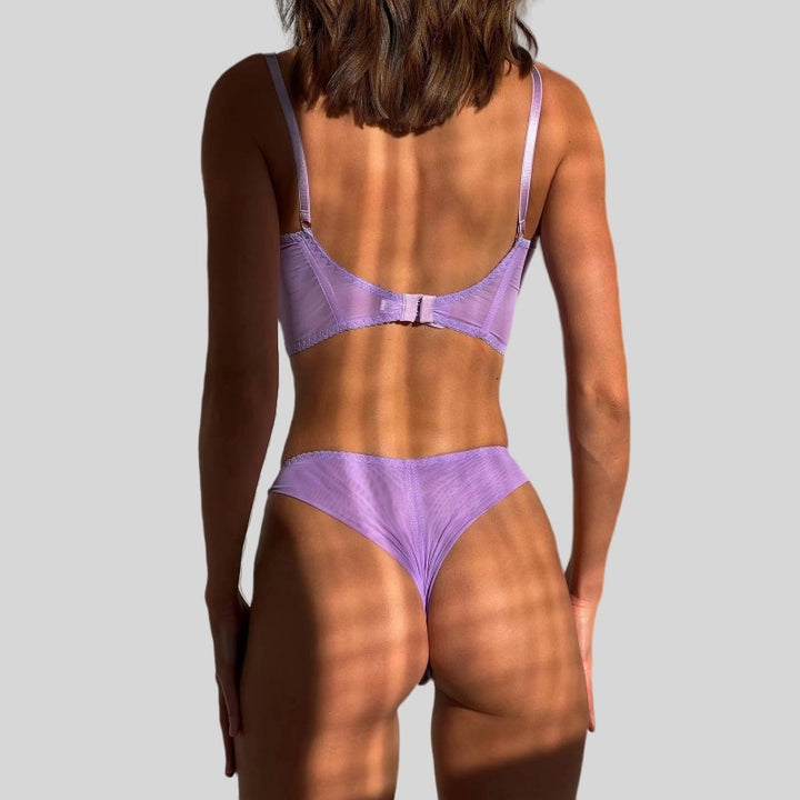 Back view of a model wearing a lavender lingerie set, featuring a comfortable bralette with adjustable straps and a matching brief. The soft fabric and delicate design