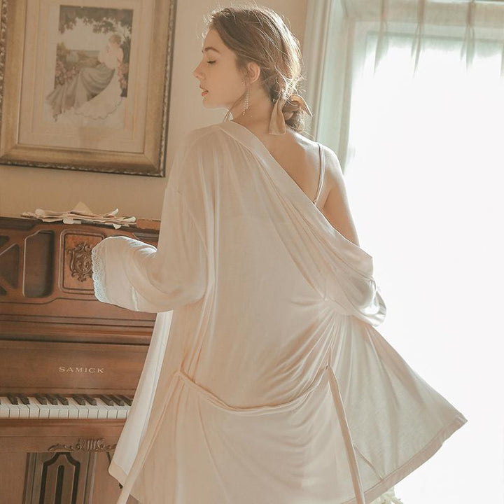 Elegant lingerie nightwear in soft pastel color, featuring a draped design and lacy accents, showcased by a model with a graceful pose near a piano.