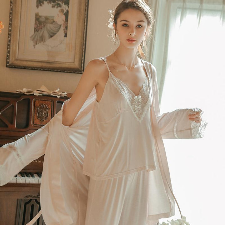 Elegant lingerie set featuring a delicate lace-trimmed camisole and matching robe, styled on a model in a softly lit room.