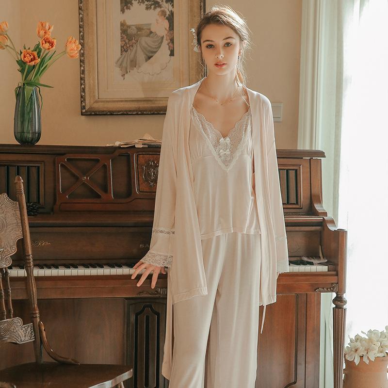 Elegant women’s lingerie set featuring a delicate lace camisole and matching pajama pants, styled with a long sheer robe, perfect for a luxurious nightwear experience.