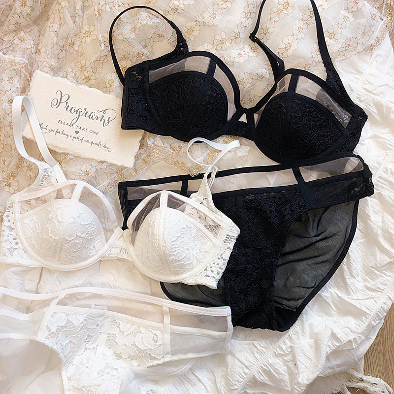 A collection of elegant lace lingerie sets in black and white, featuring bras and matching panties laid out on a textured background.