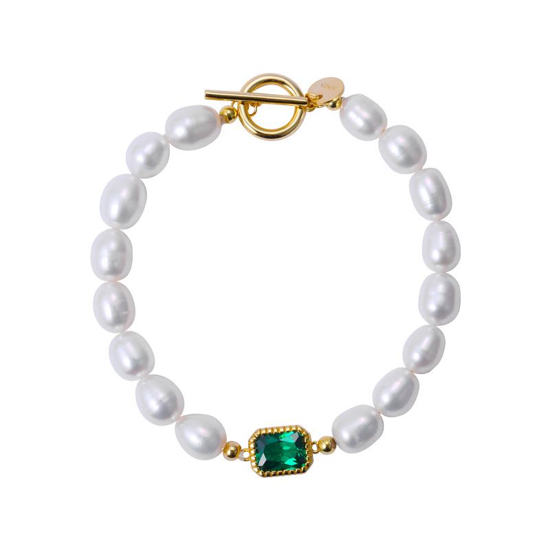 Elegant bracelet featuring lustrous white pearls and a central green gem accent, secured with a gold toggle clasp.