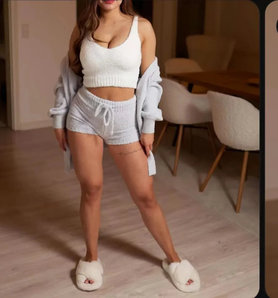 Cozy two-piece lounge set featuring a soft white crop top and grey shorts, complemented by a light cardigan and fluffy slippers, perfect for relaxation.