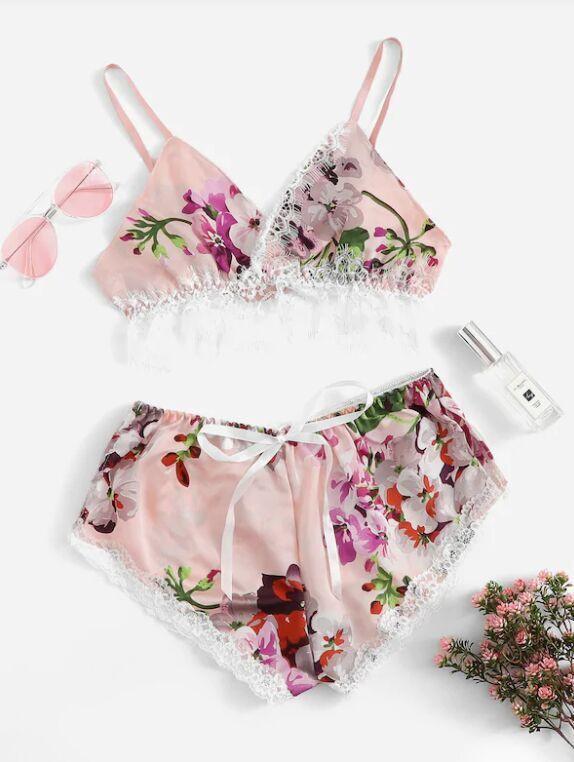 Floral lace trim bralette and matching shorts set in soft pink, featuring vibrant flower patterns and delicate lace details, styled with accessories.