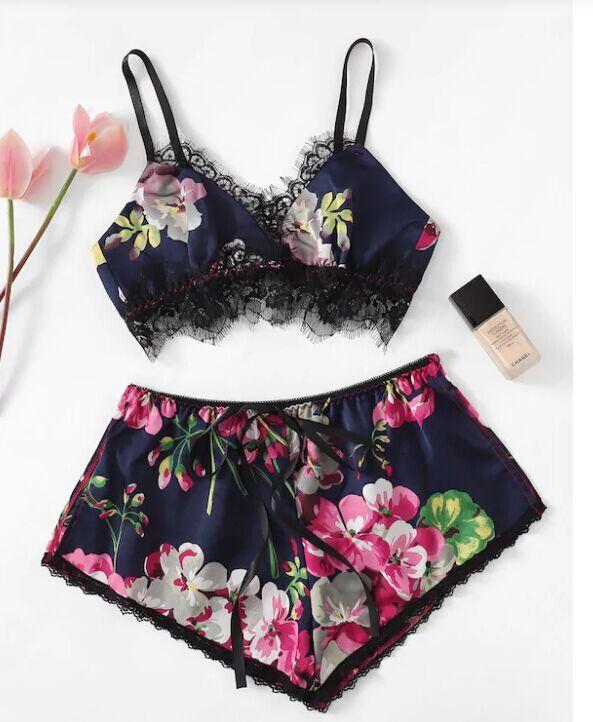 Floral lace bralette and shorts set in navy blue with pink and white flowers, featuring black lace trim and adjustable straps.