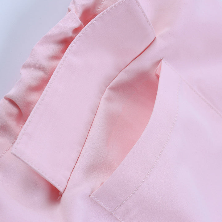 Close-up of soft pink satin fabric showcasing delicate stitching and pocket details in lingerie and nightwear collection.