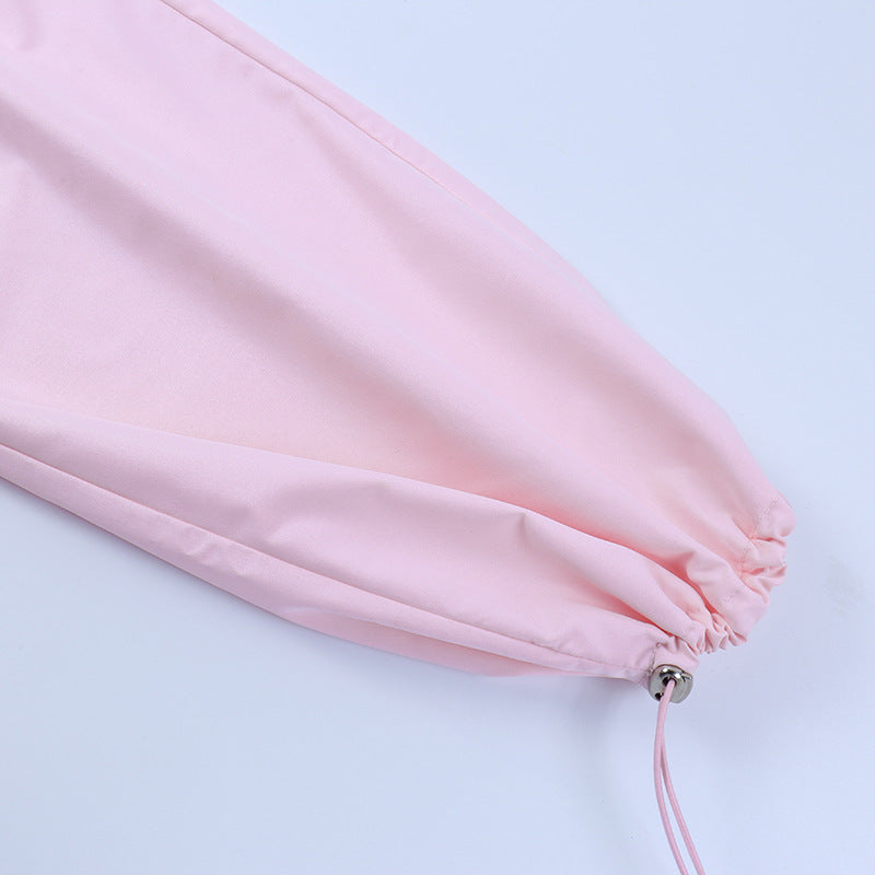 Close-up of a soft pink lingerie bandeau top with adjustable drawstring detailing.