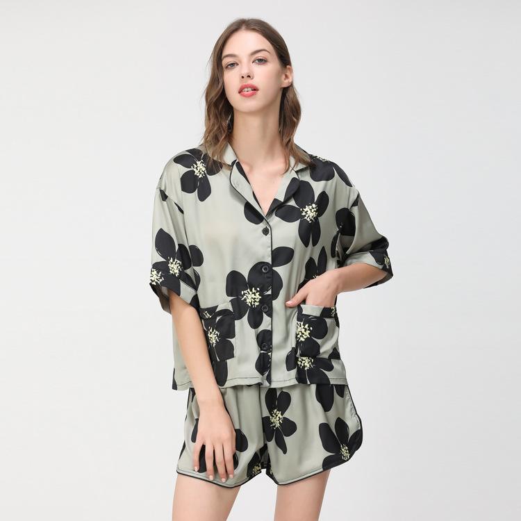 Floral print satin short pajama set in green and black, featuring a short-sleeved button-up top and matching shorts.