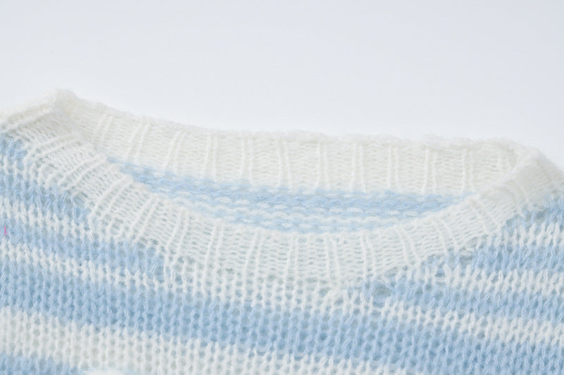 Soft knitted sweater with white and light blue stripes, featuring a ribbed neckline and delicate texture.