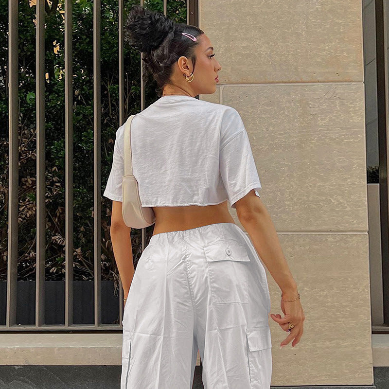 Model wearing a cropped white t-shirt paired with white cargo pants, showcasing a casual and stylish look from the back.