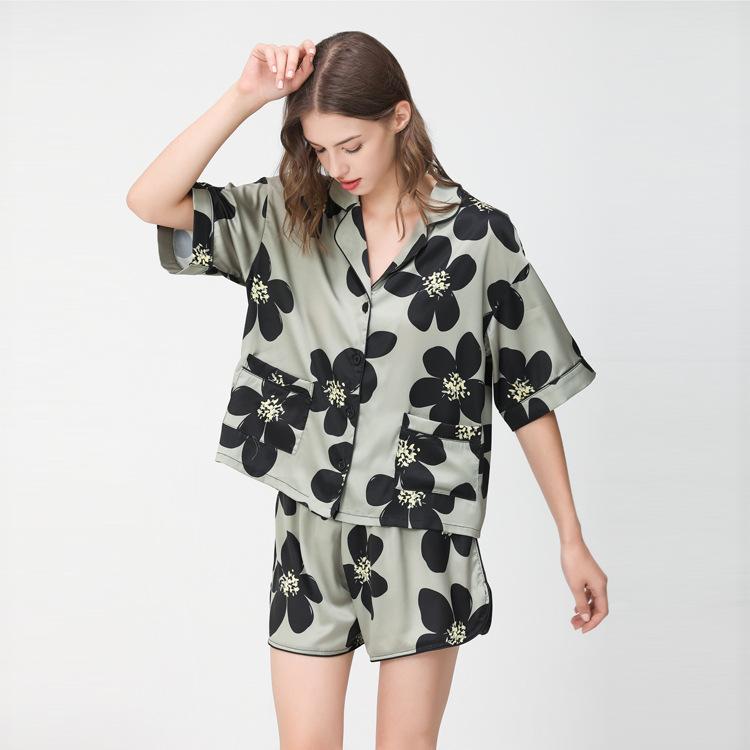 Women's floral print satin pajama set featuring a short-sleeve button-up shirt and matching shorts in a soft green color.