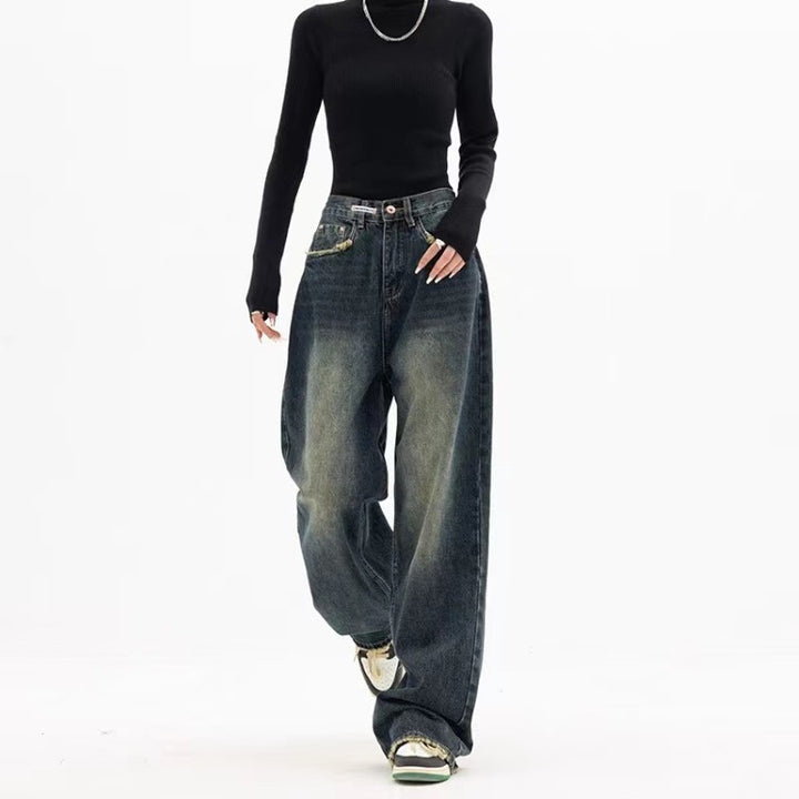 Loose-fit high-waisted jeans styled with a black long-sleeve top and casual sneakers, perfect for a trendy streetwear look.