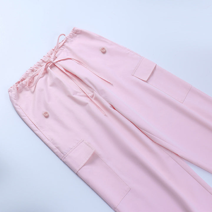 Soft pink women's lounge pants featuring an elastic waist with drawstring and side pockets, designed for comfort and style.