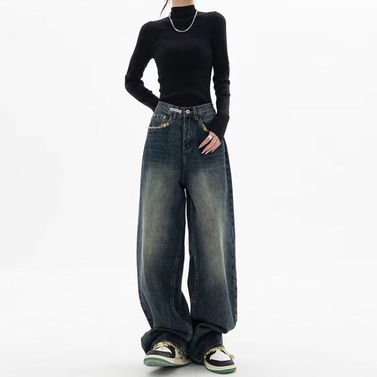 Product image showcasing a model wearing a fitted black long-sleeve top paired with oversized blue denim jeans, styled with casual sneakers and accessories.